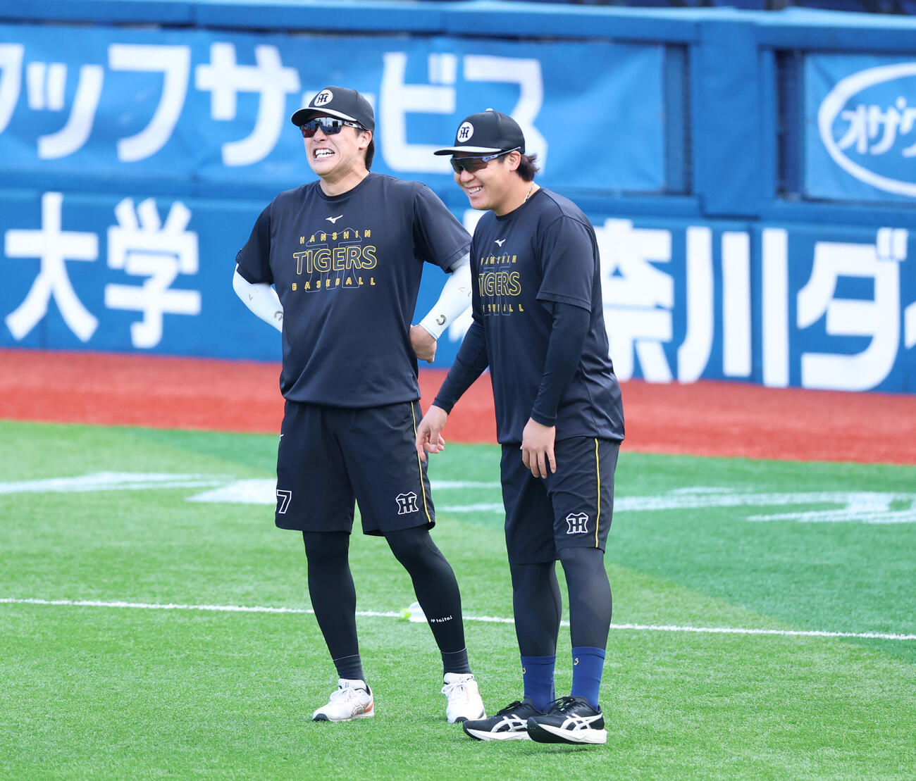 DeNA対阪神　アップ中、笑顔を見せる阪神伏見寅威（左）と大山悠輔（撮影・増田悦実）