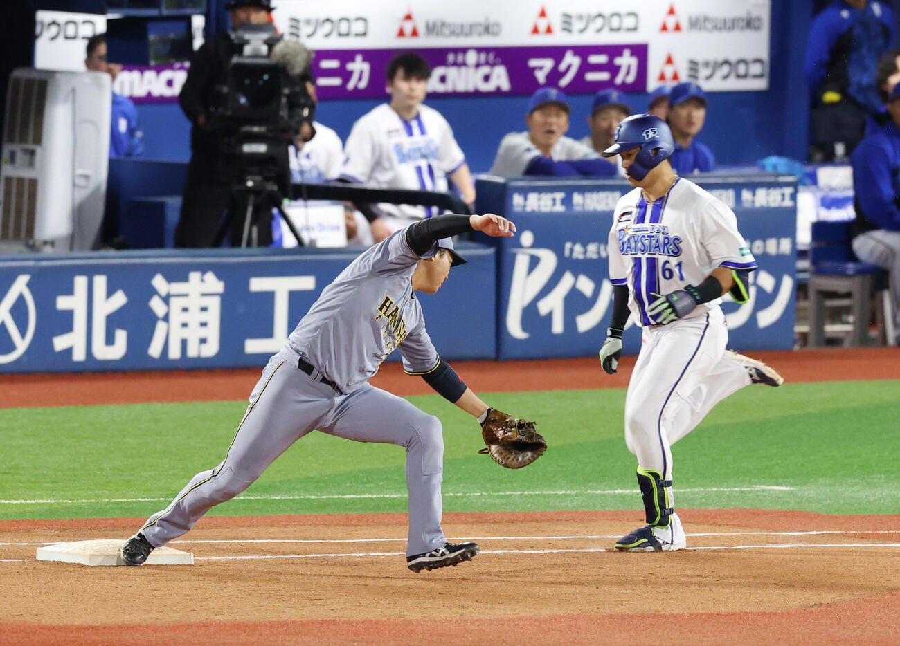 DeNA対阪神　4回裏DeNA1死、佐藤輝明の悪送球で出塁する蝦名達夫。左は大山悠輔（撮影・増田悦実）