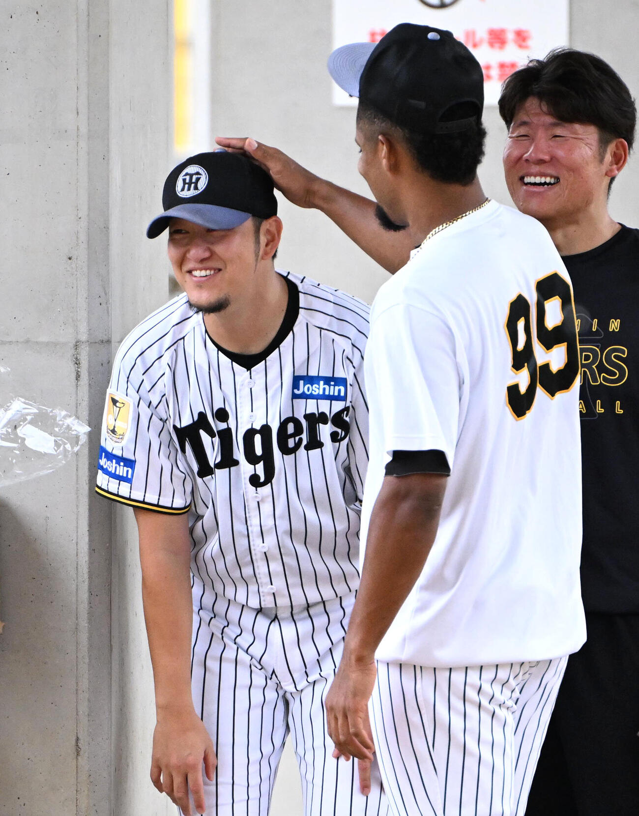 阪神ダウリ・モレッタ（右）に頭をなでられる阪神岩貞祐太（撮影・石井愛子）