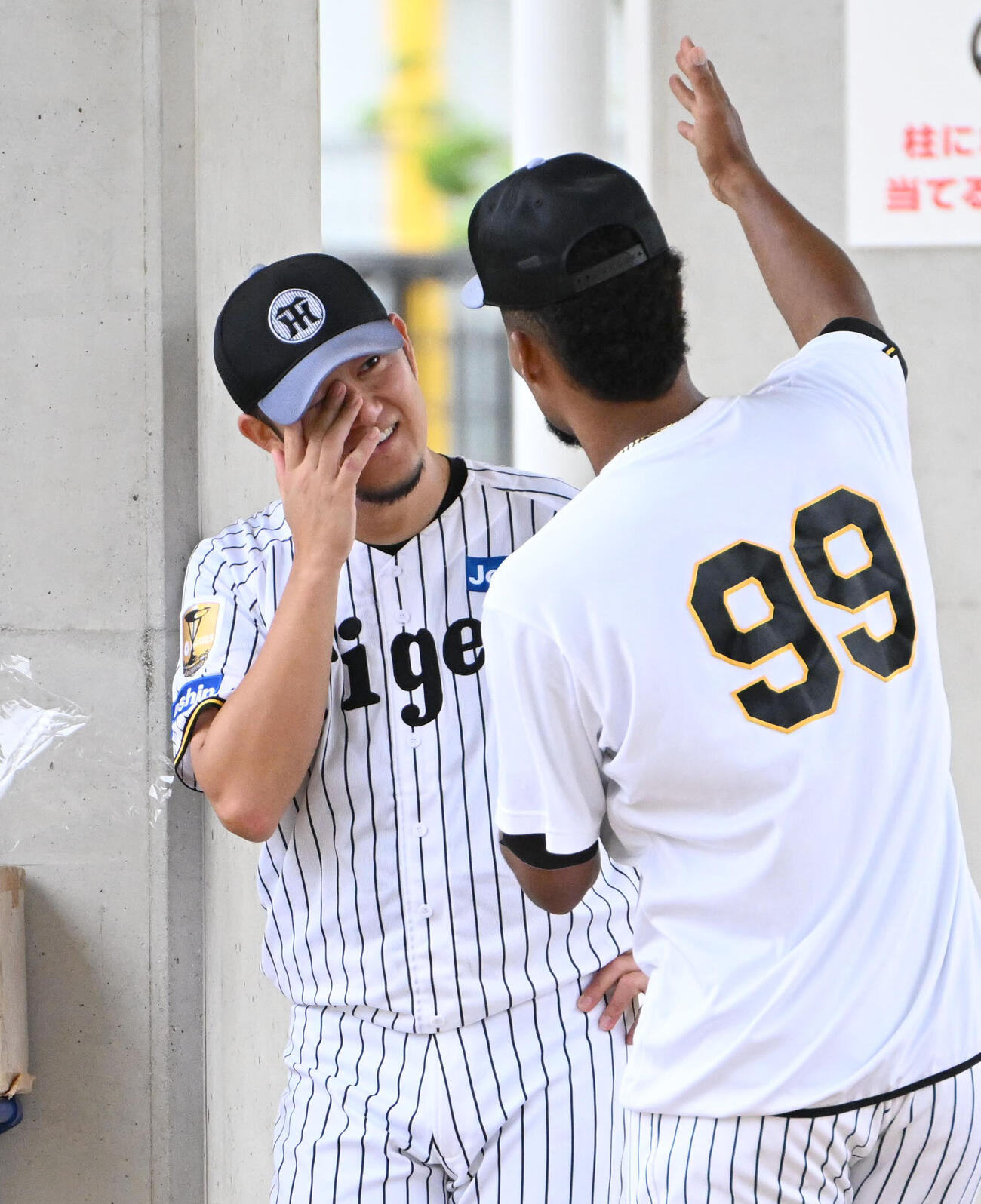 阪神ダウリ・モレッタ（右）と話し泣くフリをする阪神岩貞祐太（撮影・石井愛子）
