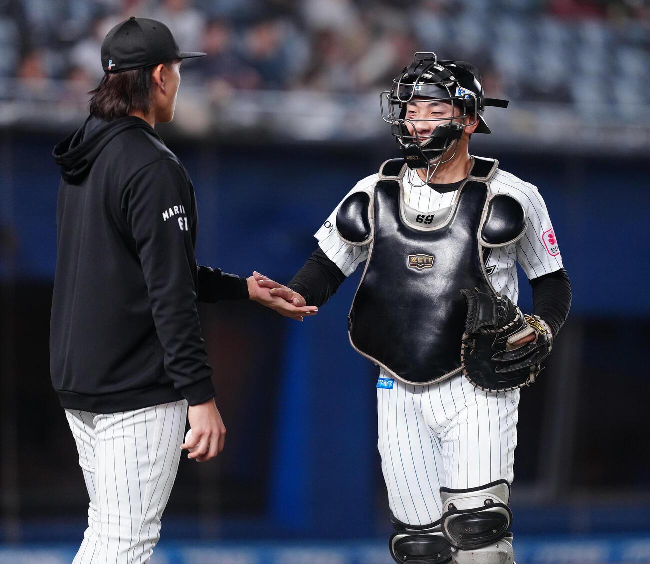 ロッテ対西武　1回表を終え、笑顔でベンチへ戻るロッテ岡村了樹（右）（撮影・鈴木みどり）