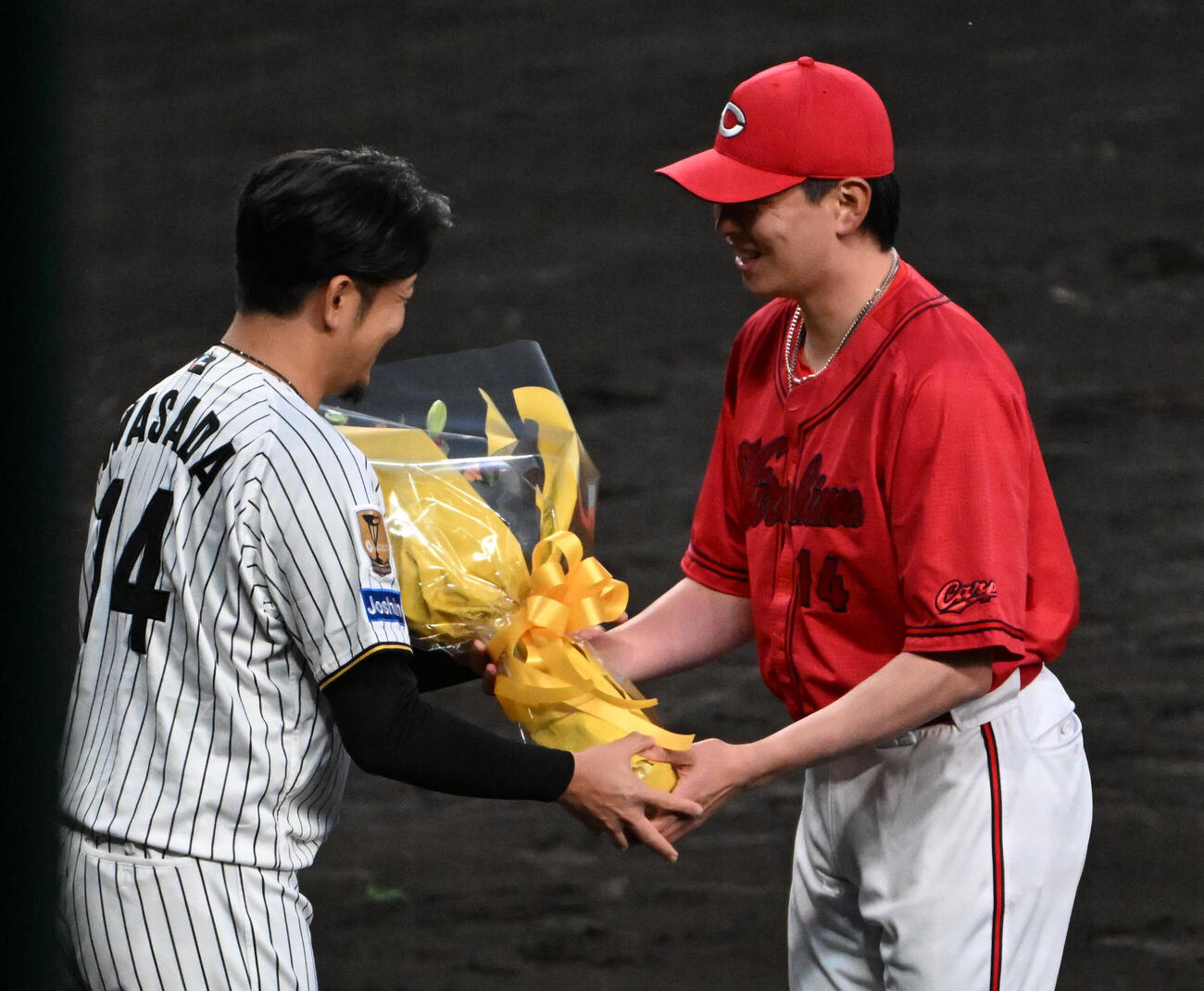 引退セレモニーで広島大瀬良大地（右）から花束を贈呈される阪神岩貞祐太（撮影・石井愛子）