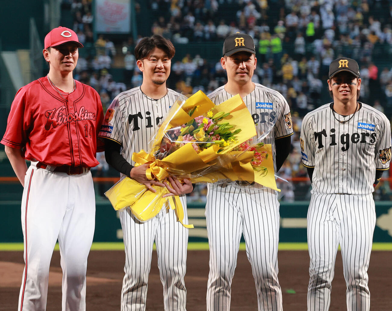 引退する阪神岩貞祐太（左から2人目）に花束を贈り記念撮影する、左から広島大瀬良大地、一人おいて阪神岩崎優、阪神梅野隆太郎（撮影・上山淳一）