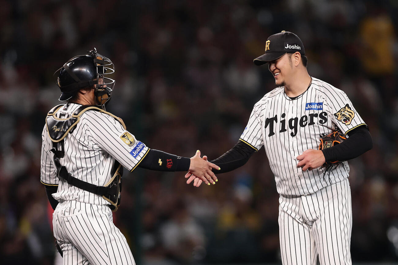 阪神対広島　7回表、登板を終え梅野隆太郎（左）と握手を交わす阪神岩貞祐太（撮影・前田充）