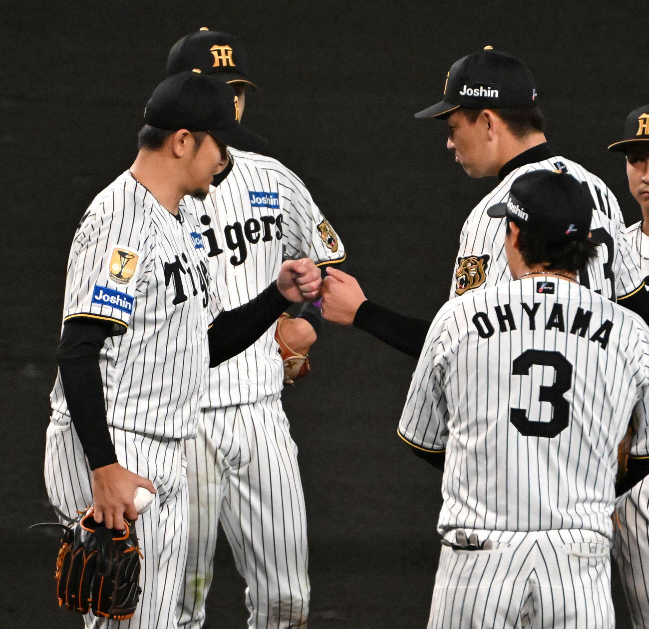 阪神対広島　7回表途中、降板する岩貞祐太（左）は岩崎優と拳を合わせる（撮影・石井愛子）
