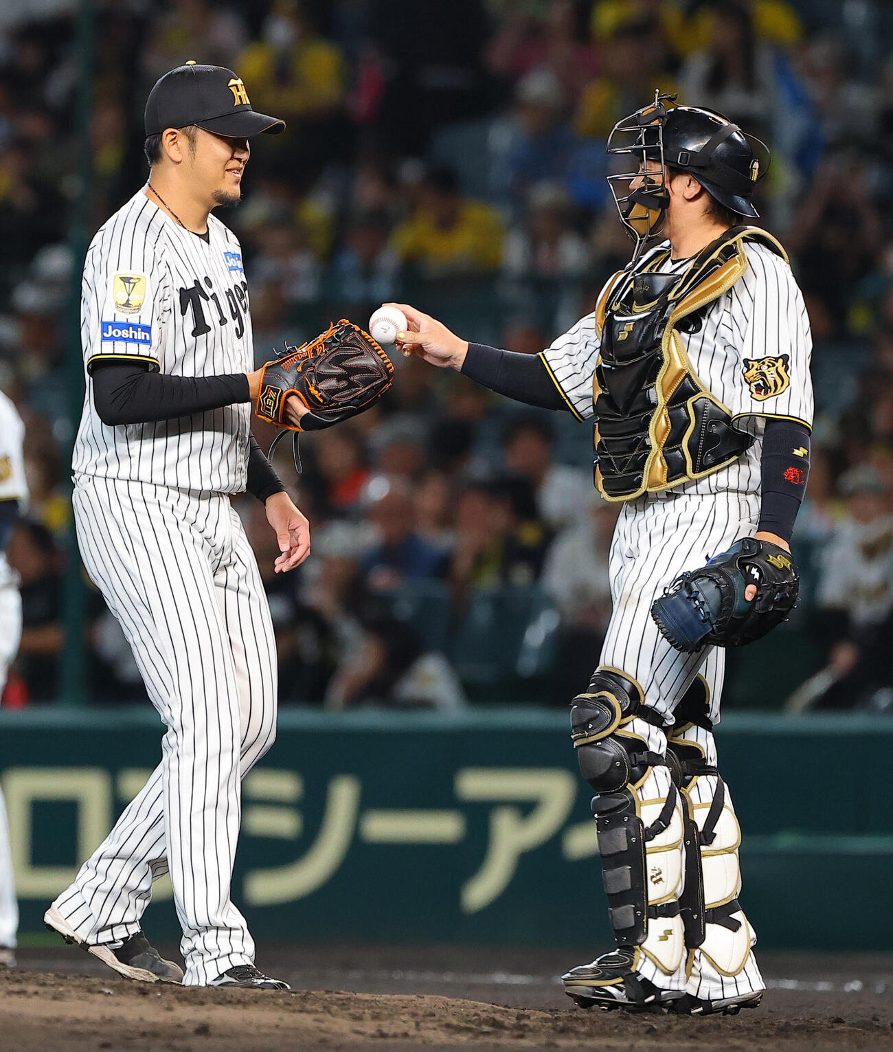 阪神対広島　7回2番手で登板する岩貞祐太（左）は梅野隆太郎からボールを受け取る（撮影・上田博志）