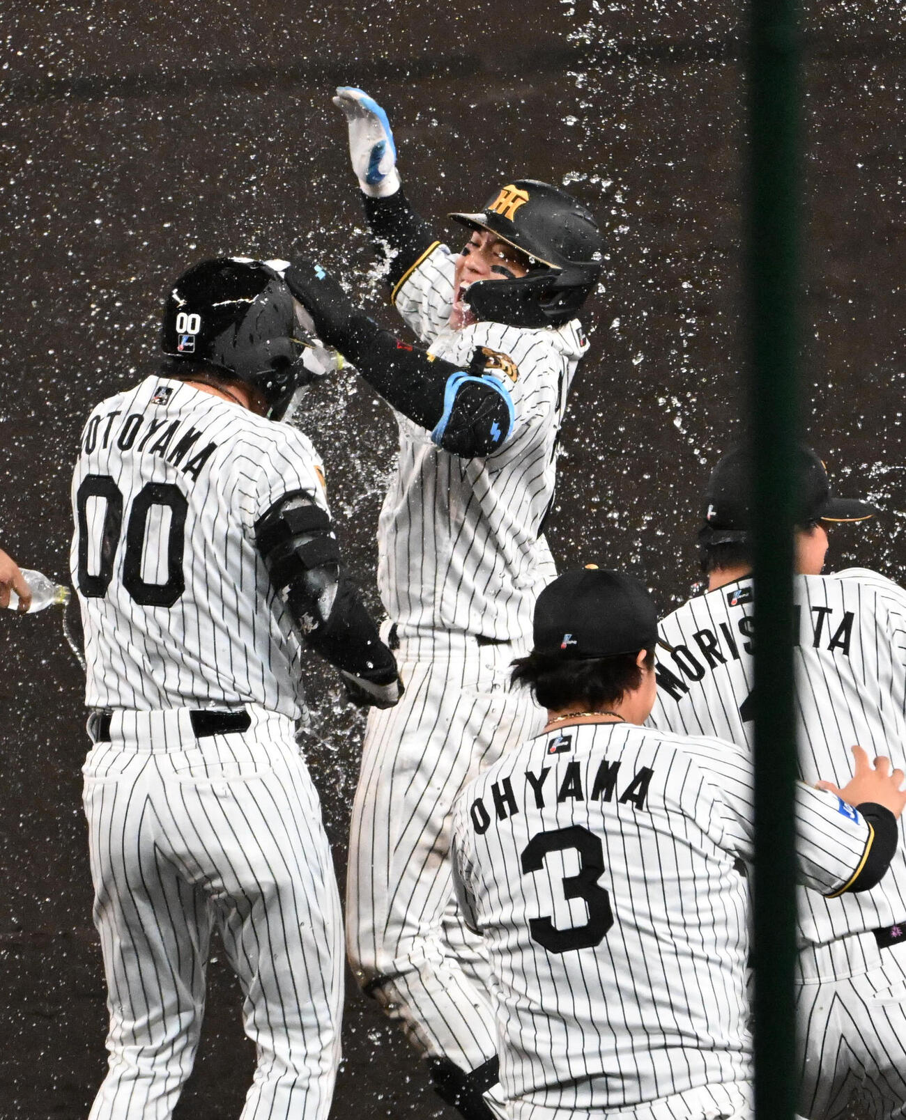 阪神対広島　11回裏阪神1死二、三塁、サヨナラ適時打を放った梅野隆太郎（中央）はウオーターシャワーの祝福を受ける（撮影・石井愛子）