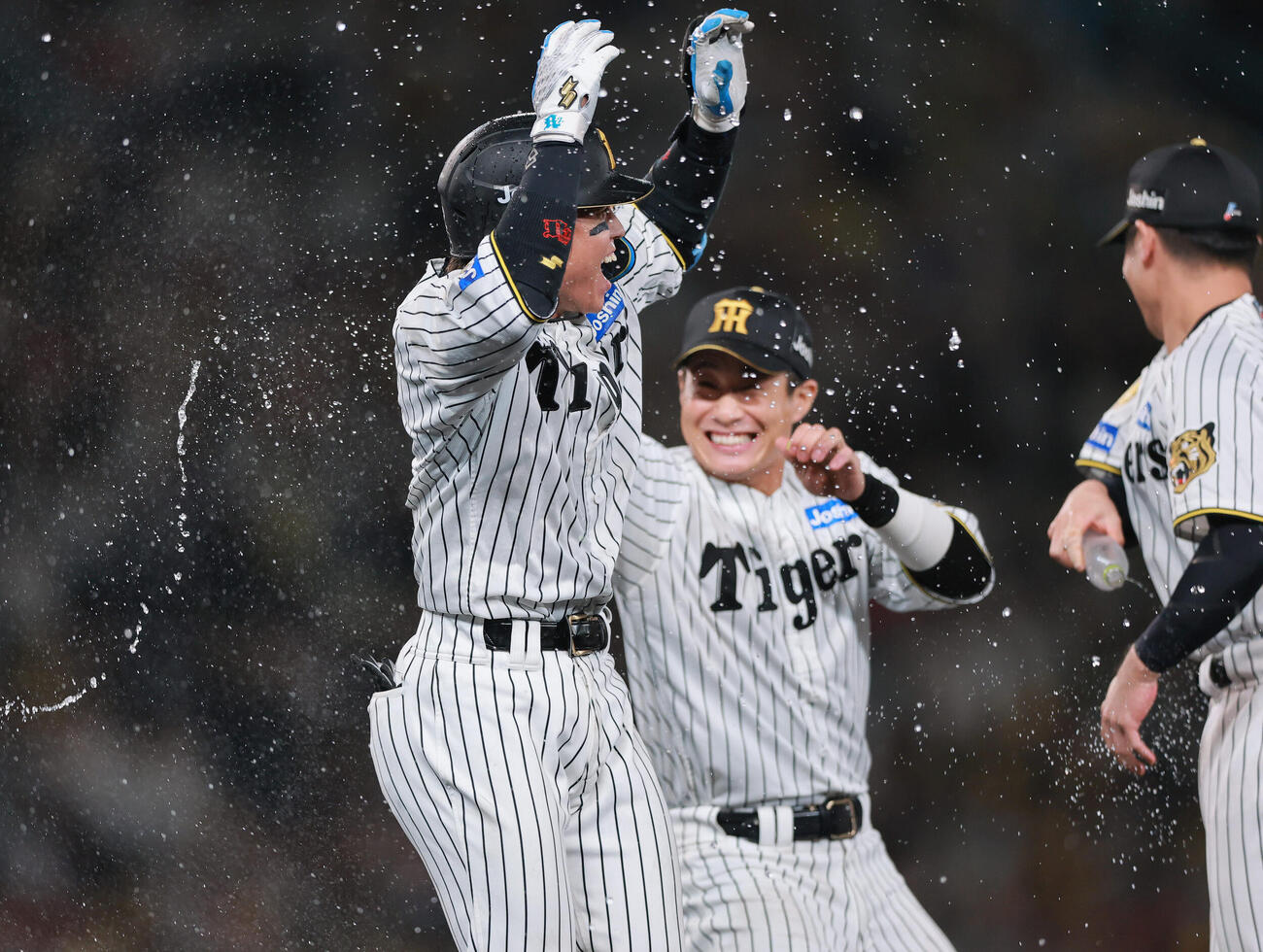 阪神対広島　11回裏阪神1死二、三塁、梅野隆太郎（手前）はサヨナラ適時打を放ナインの祝福を受ける（撮影・上山淳一）