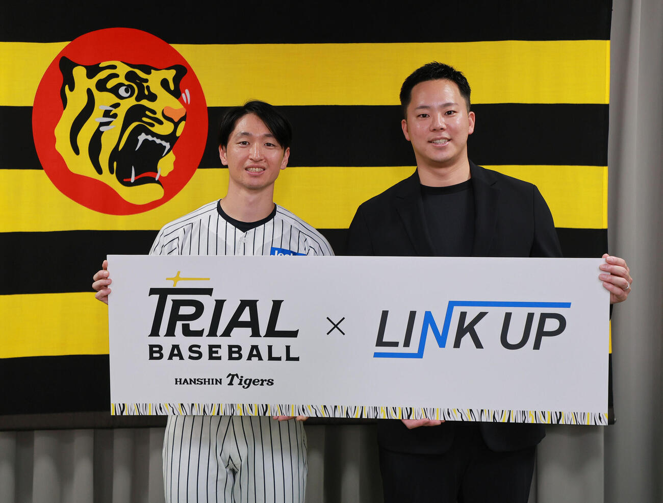 フォトセッションで笑顔を見せる阪神近本光司（左）とLINK UPの石井僚介代表理事（撮影・上山淳一）