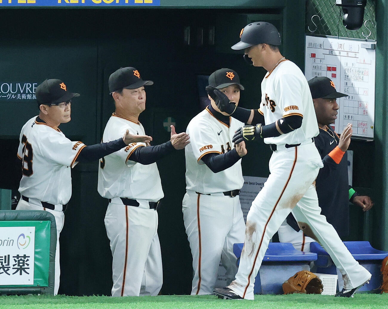 巨人対DeNA 1回裏巨人1死三塁、泉口友汰の一ゴロで生還し橋上秀樹監督代行（左から2人目）らとタッチを交わす吉川尚輝（手前）（撮影・宮地輝）