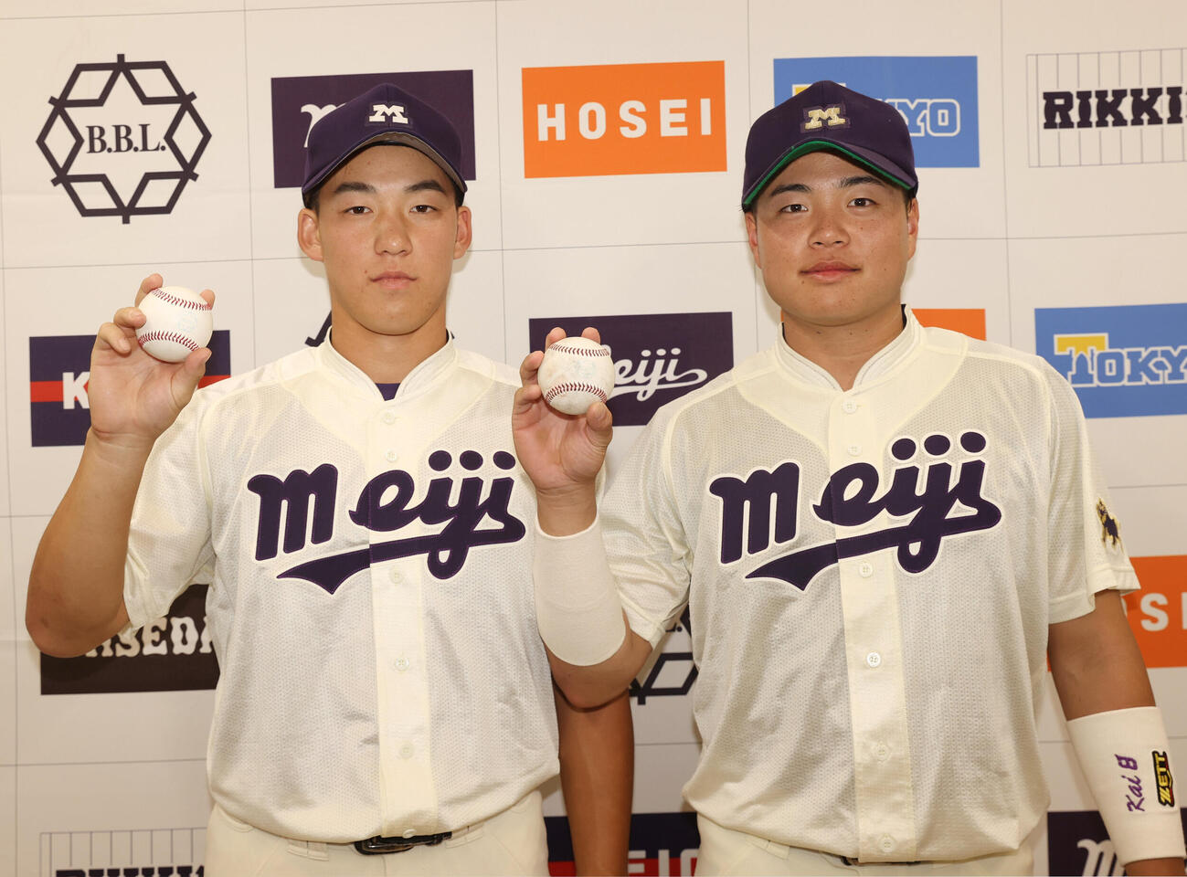 法大対明大　勝利した明大・若狭遼之助（左）と田上夏衣は本塁打のボールを持ちガッツポーズする（撮影・柴田隆二）