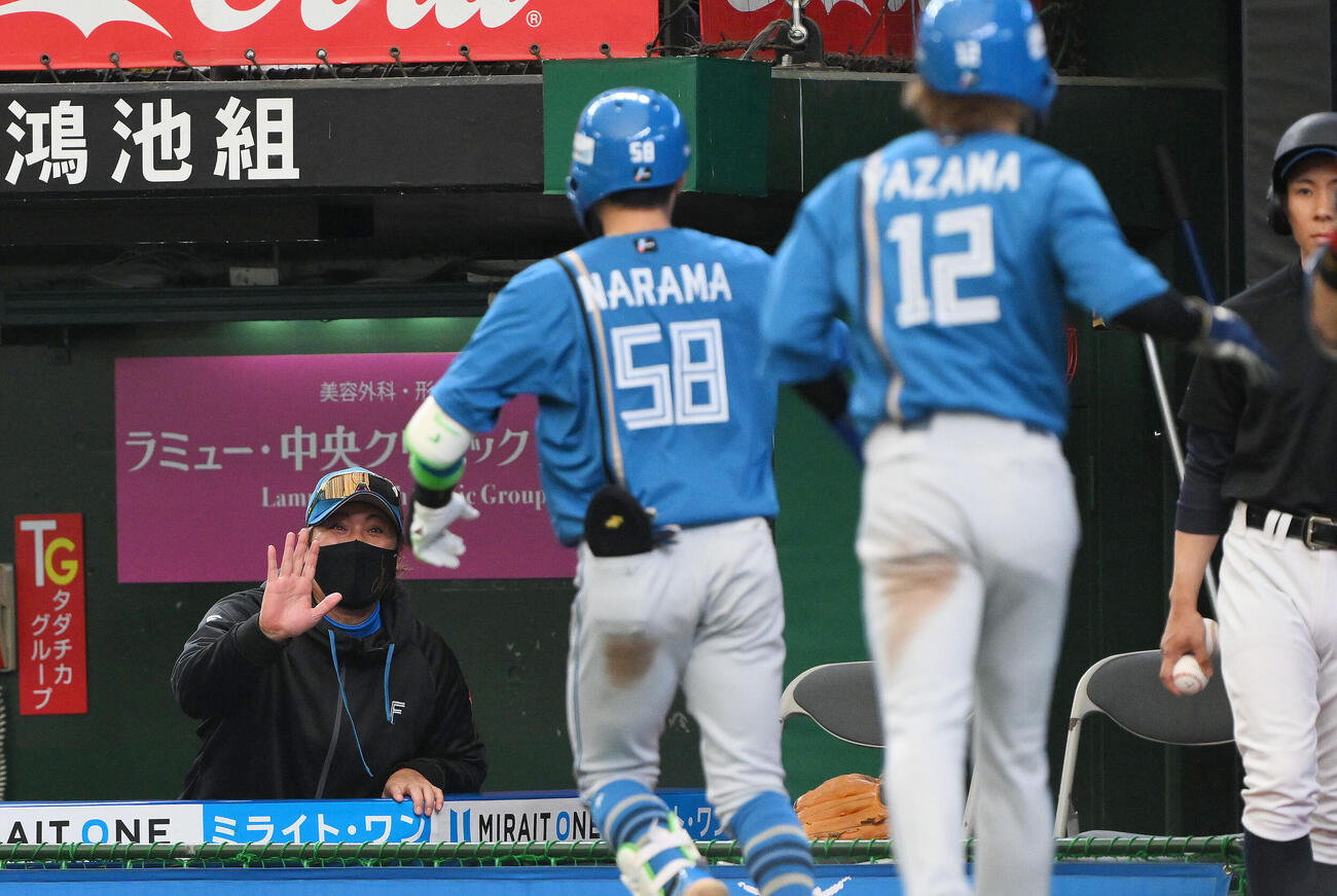 西武対日本ハム　4回表日本ハム2死二塁、2点本塁打を放った奈良間大己（中央）を迎える新庄剛志監督（左）（撮影・滝沢徹郎）