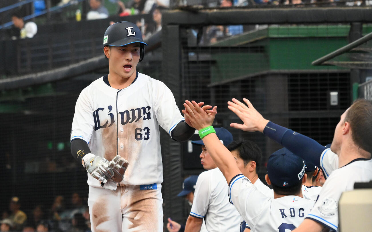 西武対日本ハム　5回裏西武1死二塁、西川愛也の適時打で生還した長谷川信哉（左）はチームメートとタッチをかわす（撮影・滝沢徹郎）