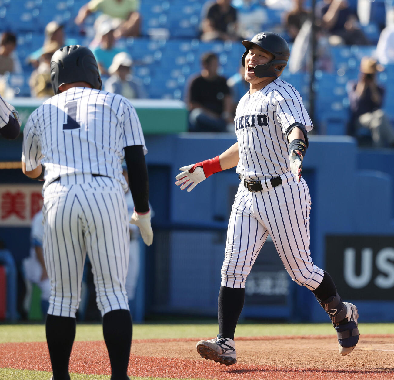 東大対立大　1回裏立大2死満塁、落合智哉（右）は満塁本塁打を放ちナインの出迎えを受ける（撮影・柴田隆二）