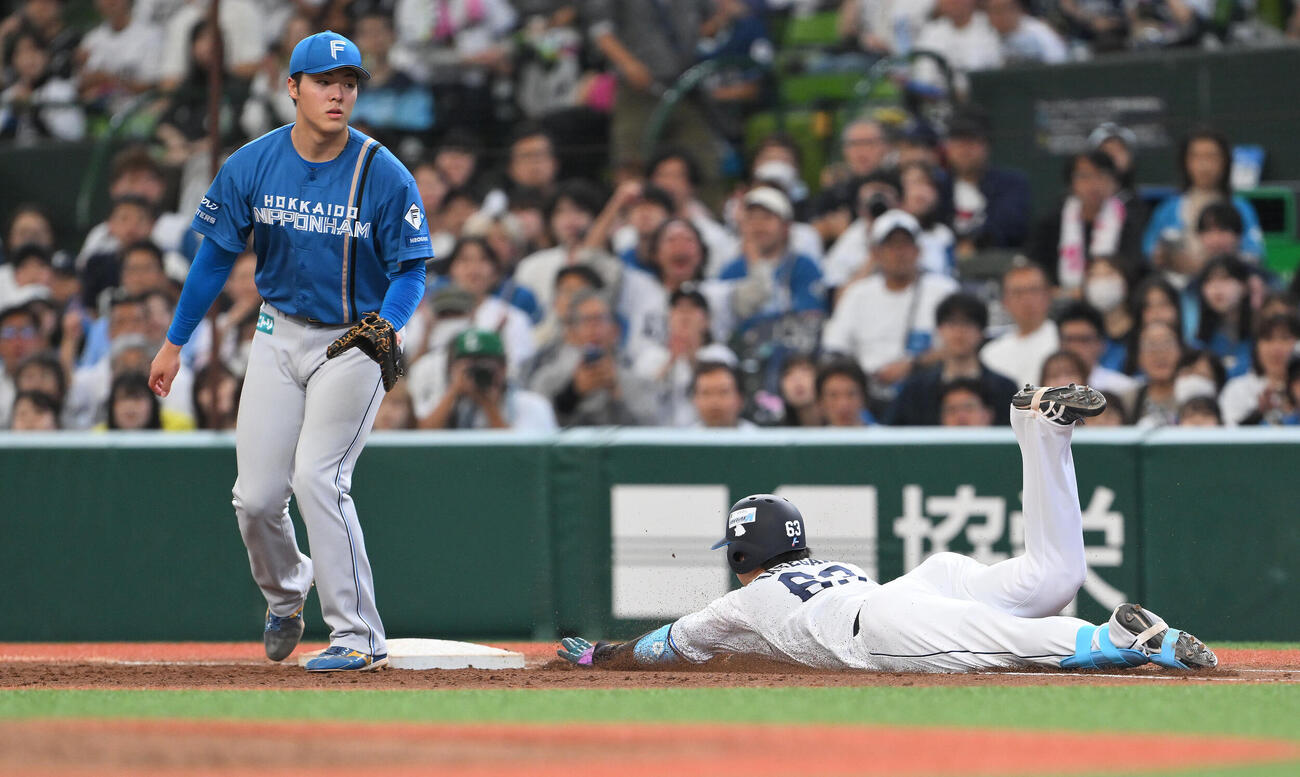 西武対日本ハム　5回裏西武無死、長谷川信哉（右）はセーフティーバントを決め一塁へヘッドスライディングする。一塁手柴田獅子（撮影・滝沢徹郎）
