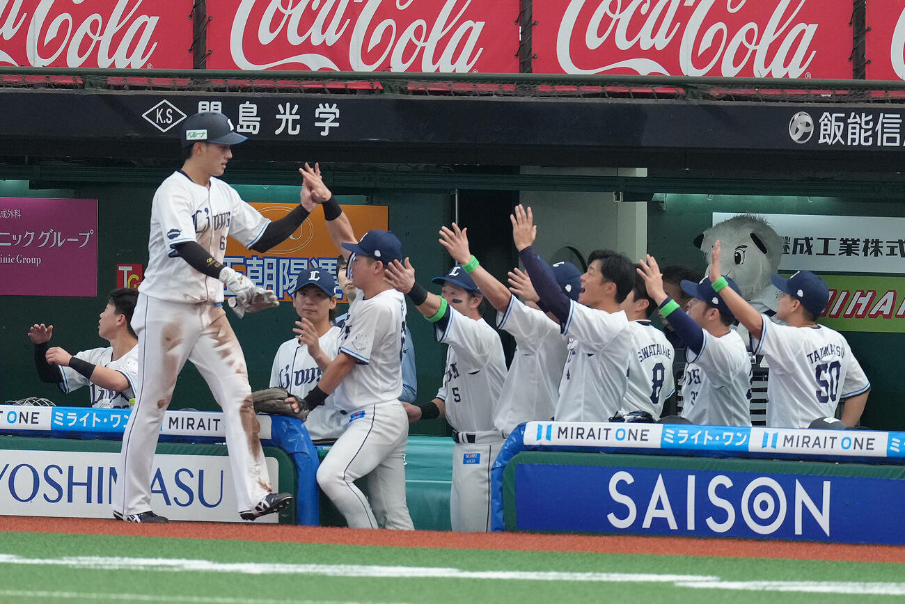西武対日本ハム　5回裏西武1死二塁、西川愛也の中前適時打で生還しタッチを交わす長谷川信哉（左端）（撮影・足立雅史）