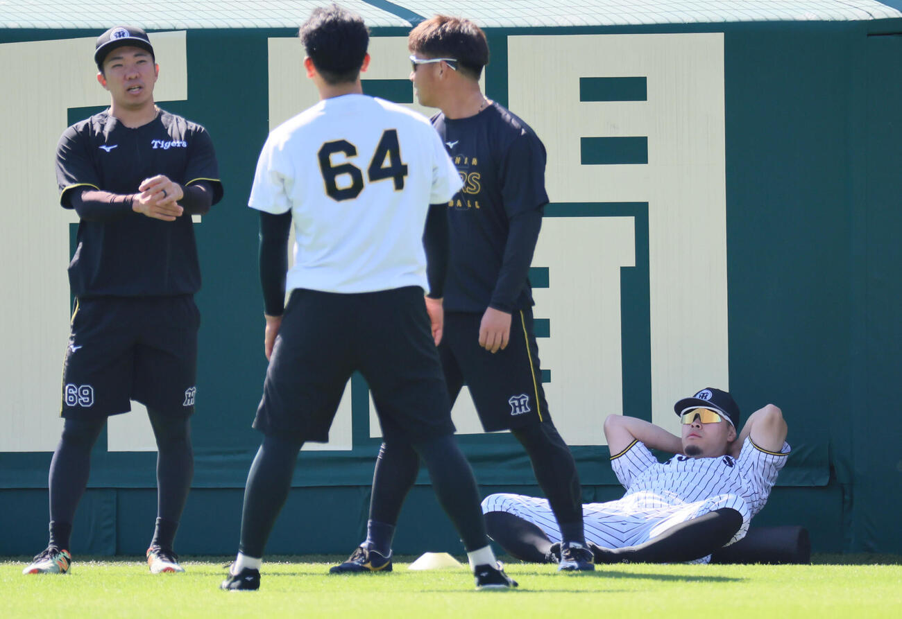 ストレッチする、左から阪神石井大智、岡留英貴、桐敷拓馬、佐藤輝明（撮影・宮崎幸一）