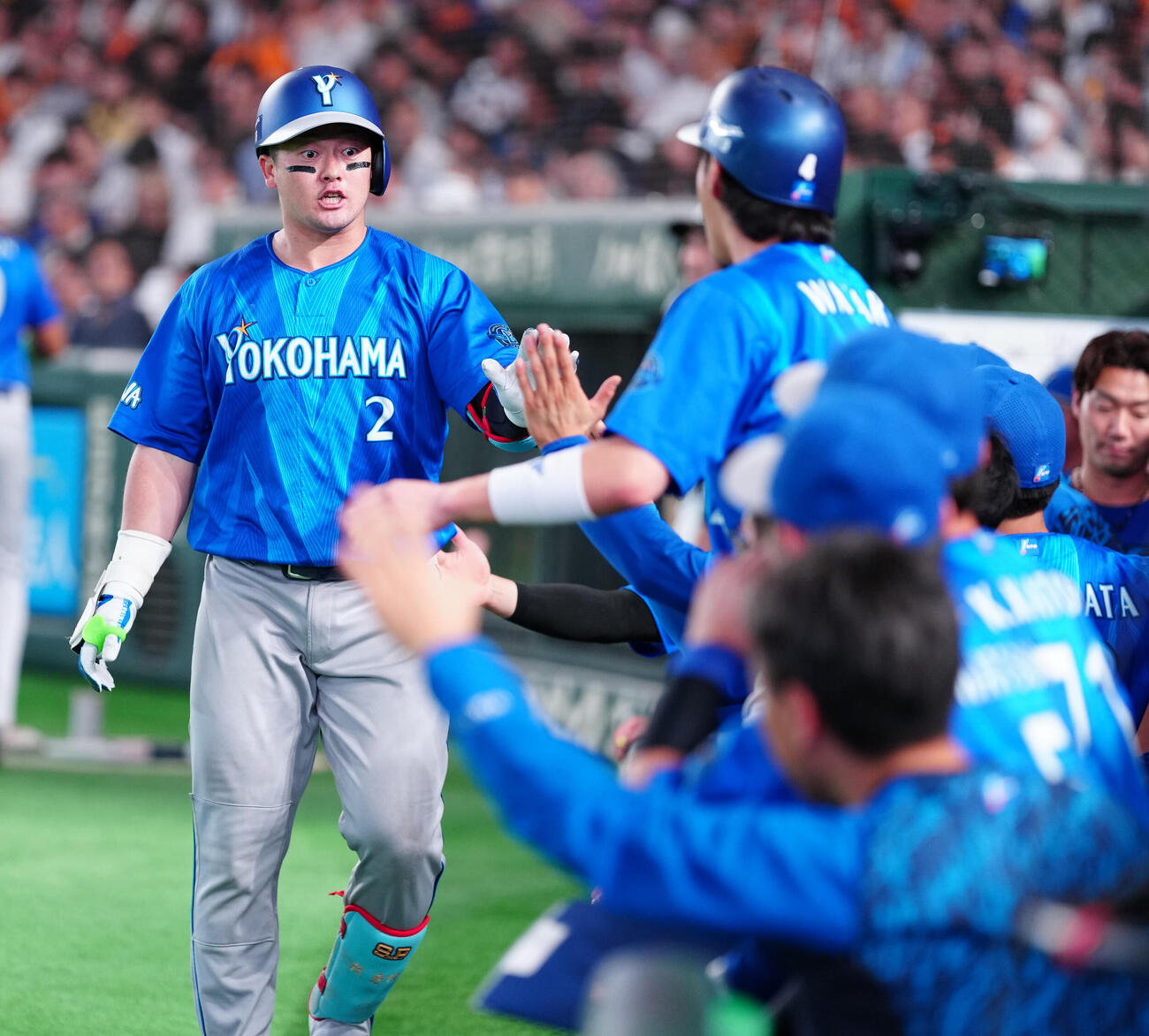 巨人対DeNA 8回表DeNA1死、ソロ本塁打を放った牧秀悟（左）はナインとハイタッチ（撮影・鈴木みどり）