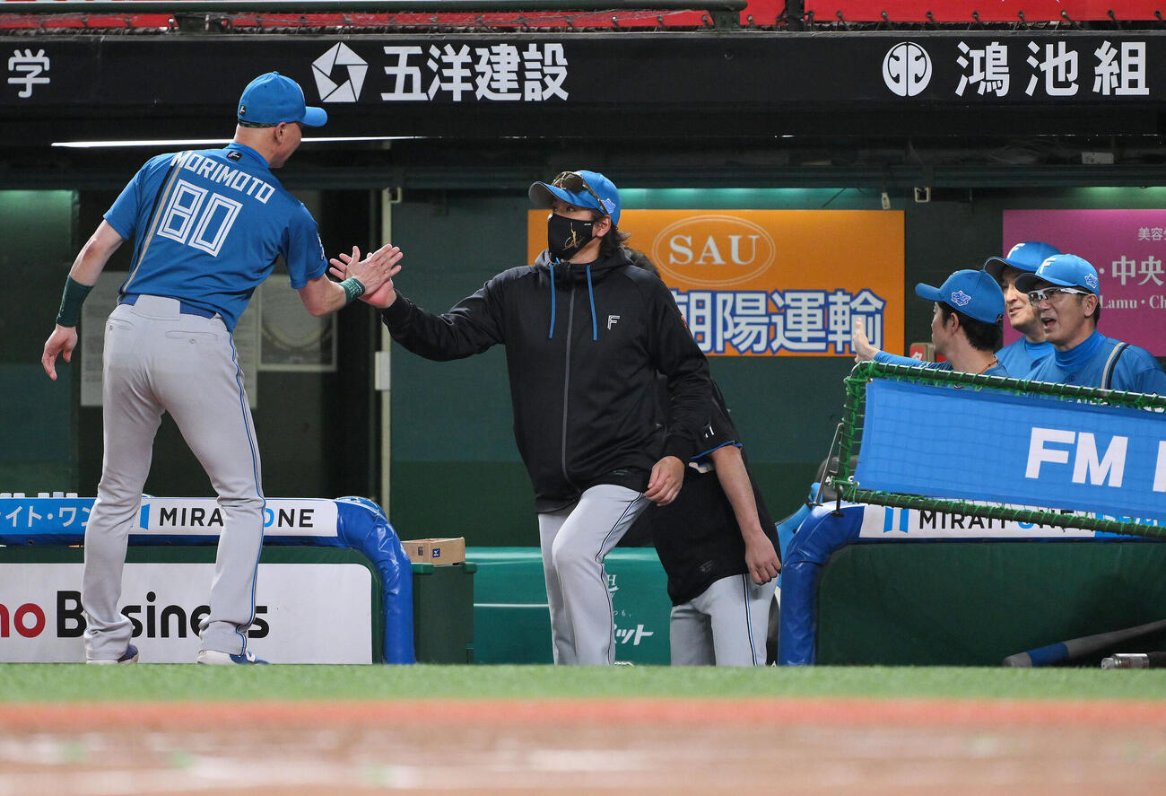 西武対日本ハム　試合に勝利し日本ハム新庄剛志監督（中央）は森本稀哲外野守備走塁コーチとタッチを交わす（撮影・滝沢徹郎）
