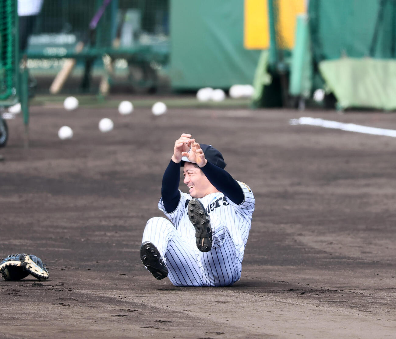 大山悠輔の打球が守備練習する阪神坂本誠志郎を直撃しグラウンドに転倒…も笑顔で起き上がる（撮影・加藤哉）