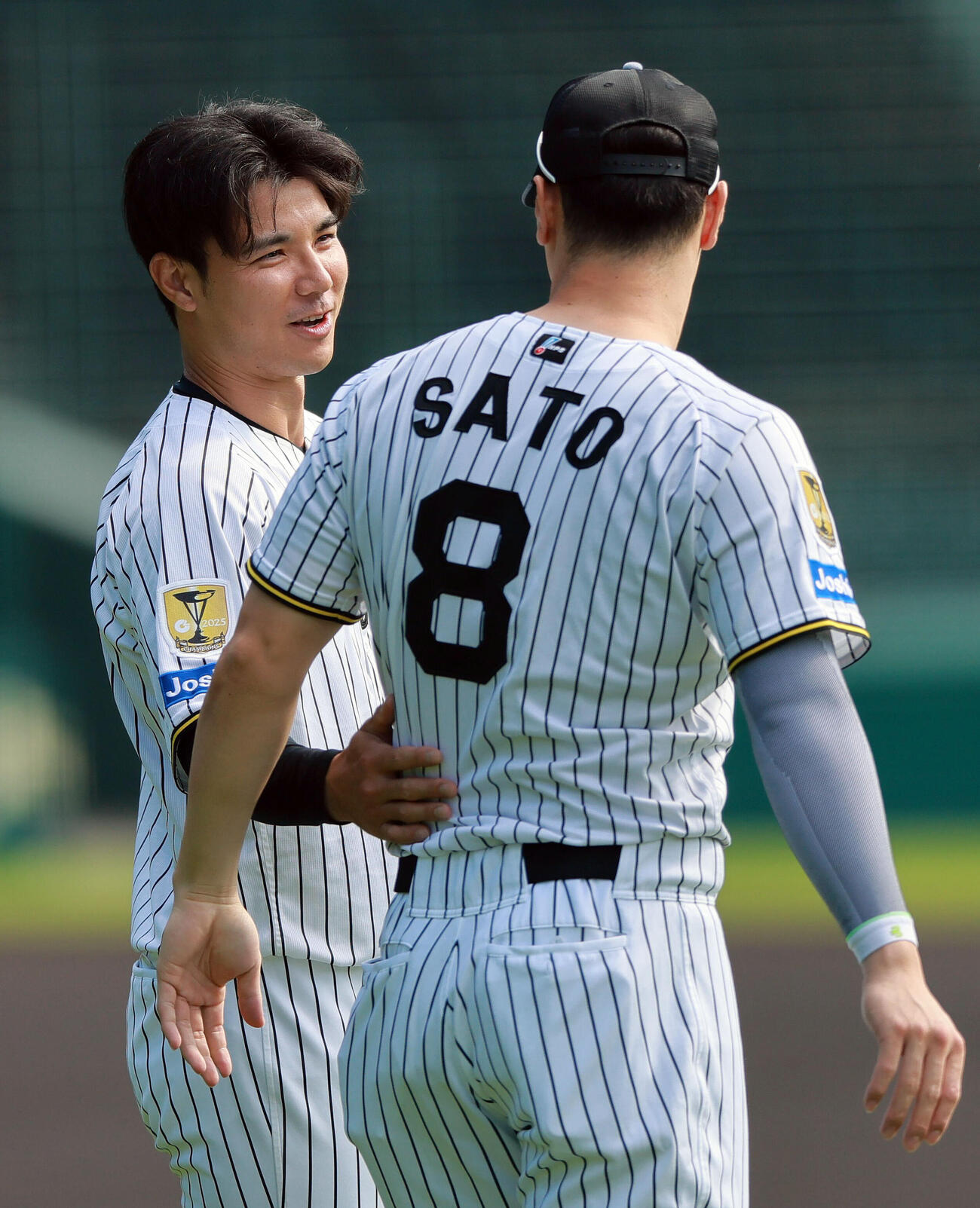 阪神佐藤輝明（手前）と話す栄枝裕貴（撮影・上山淳一）