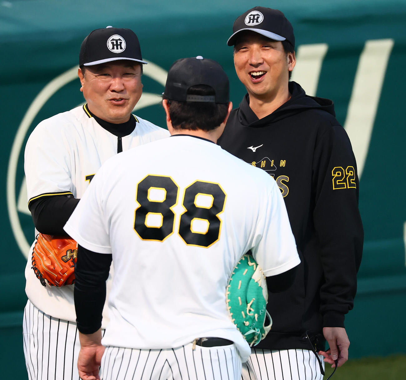 阪神藤川球児監督（右）は片山大樹コーチ（左）と並んで笑顔を見せる。手前は安藤優也コーチ（撮影・加藤哉）