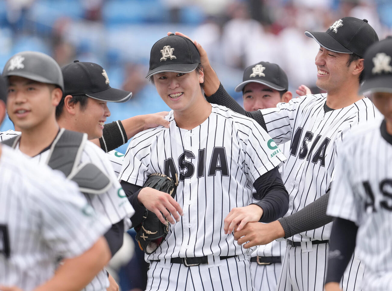 国学院大対亜大　無安打無得点試合を達成し、チームメートの祝福に笑顔を見せる亜大・川尻啓人（中央）（撮影・足立雅史）