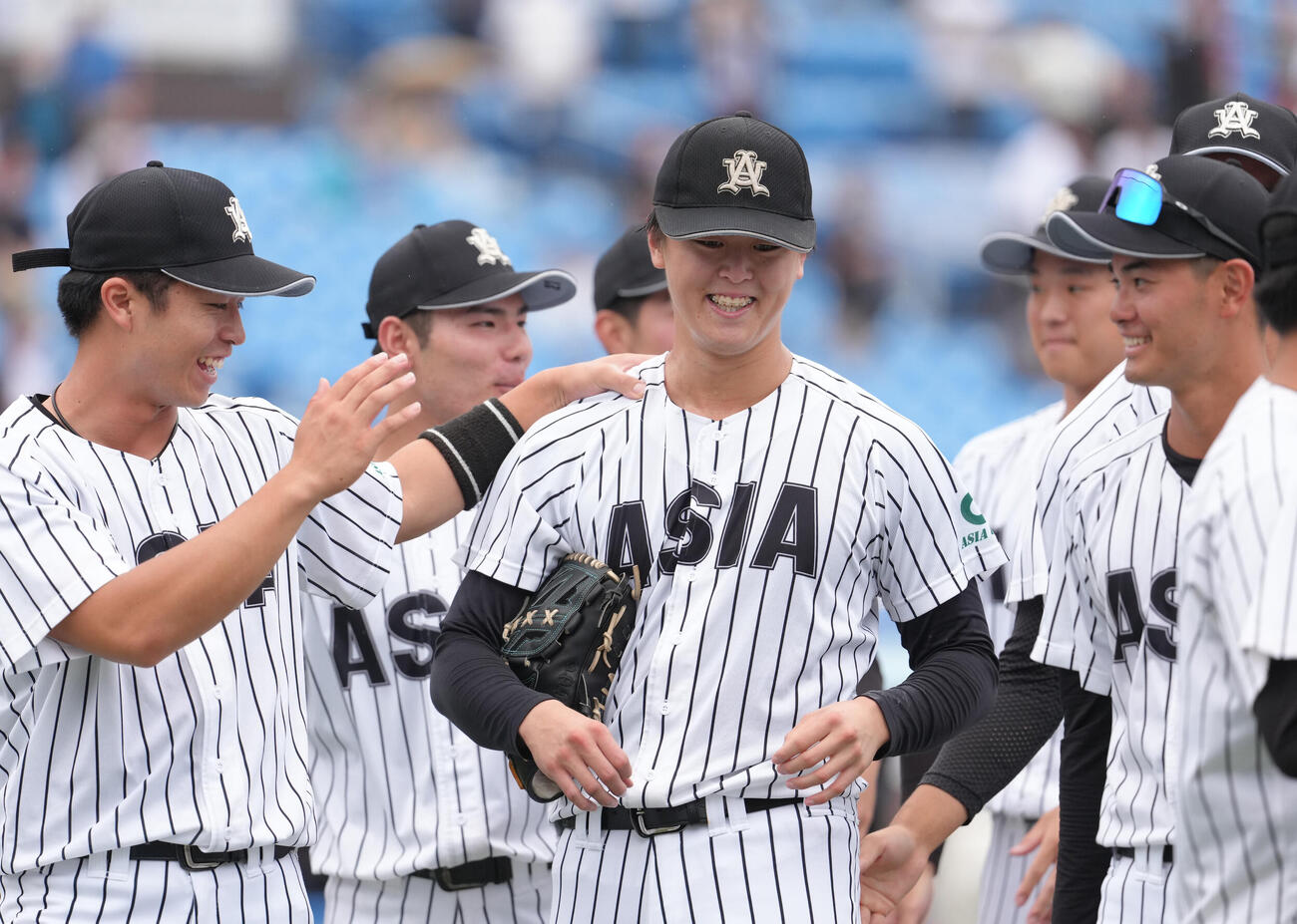 国学院大対亜大　無安打無得点試合を達成し、チームメートの祝福に笑顔を見せる亜大・川尻啓人（中央）（撮影・足立雅史）