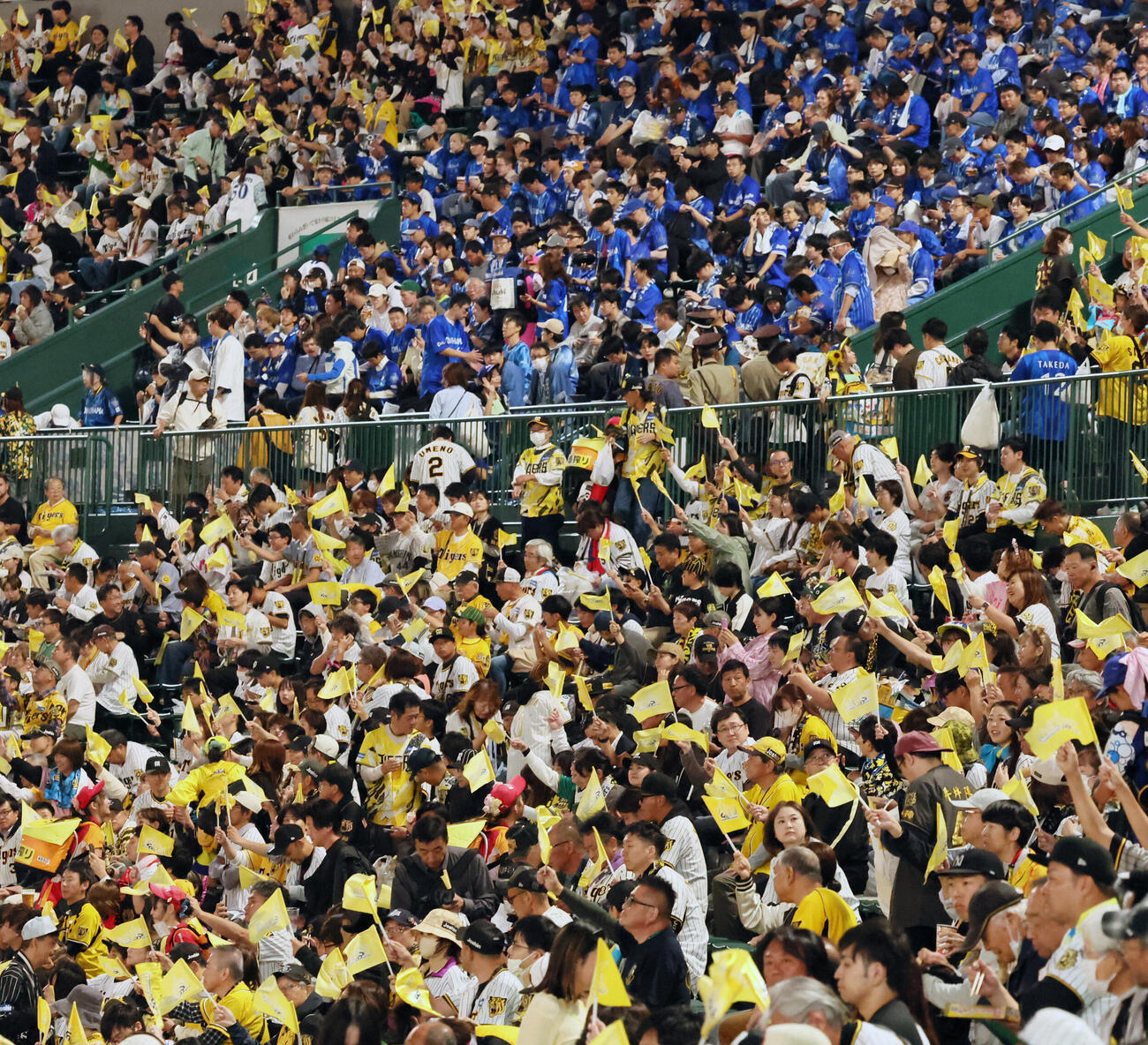 阪神対DeNA　球場入り口で配られた阪神応援フラッグを振るファン（撮影・加藤哉）