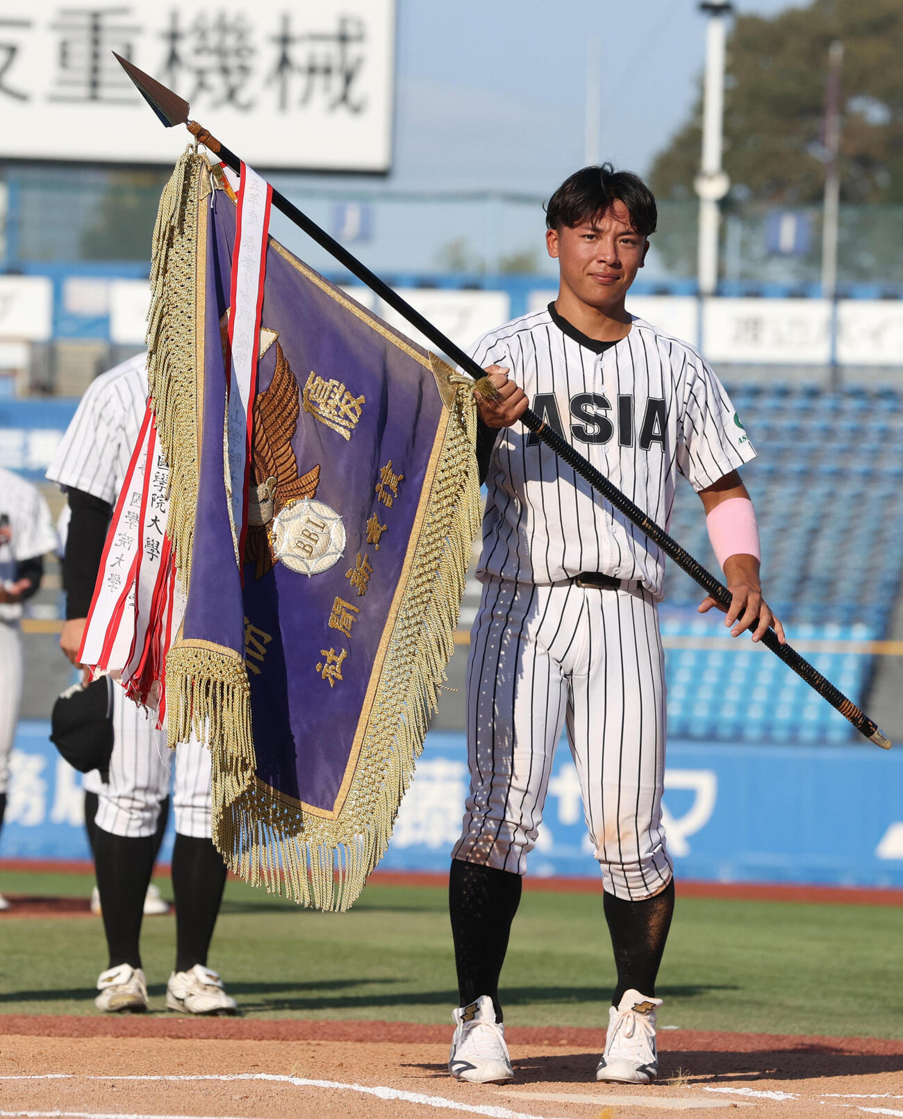 優勝旗を授与される亜大・山里宝主将（撮影・柴田隆二）