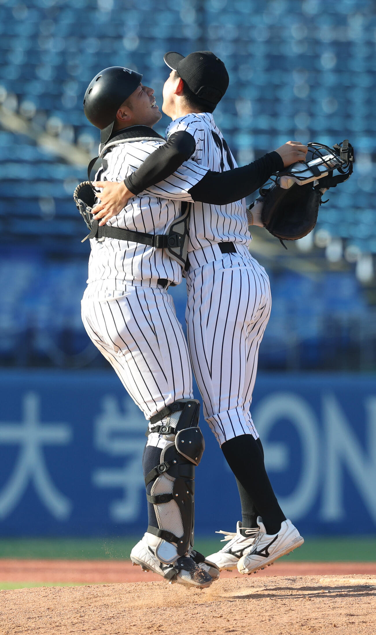 優勝した亜大・田崎颯士（右）は前嶋藍捕手と抱き合う亜（撮影・柴田隆二）