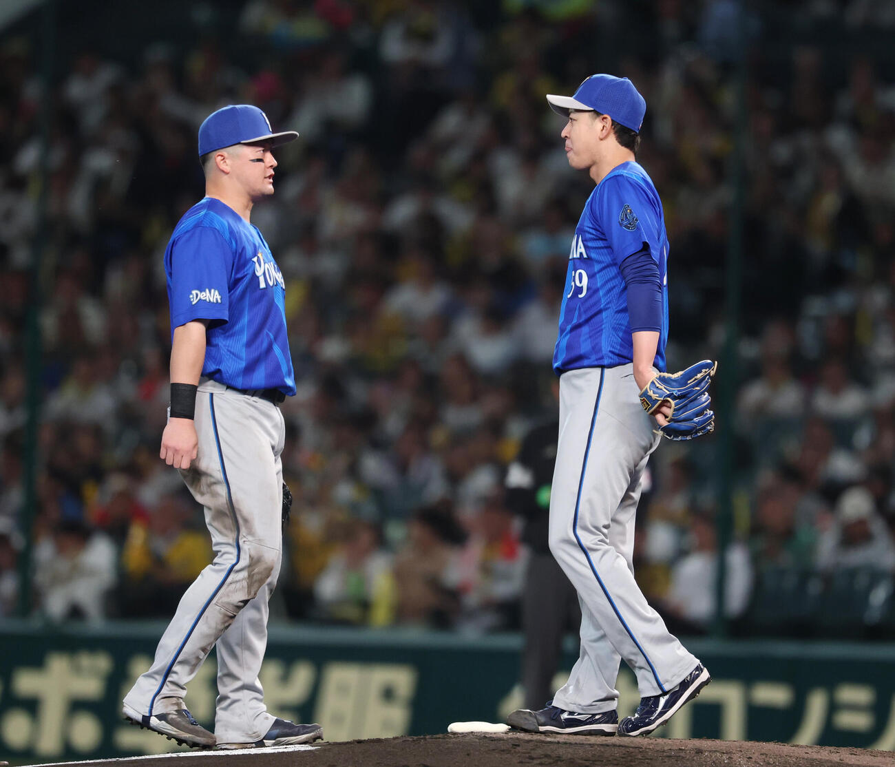 阪神対DeNA 4回裏阪神無死一塁、四球で出塁をゆるした平良拳太郎（右）に声をかける牧秀悟（撮影・増田悦実）