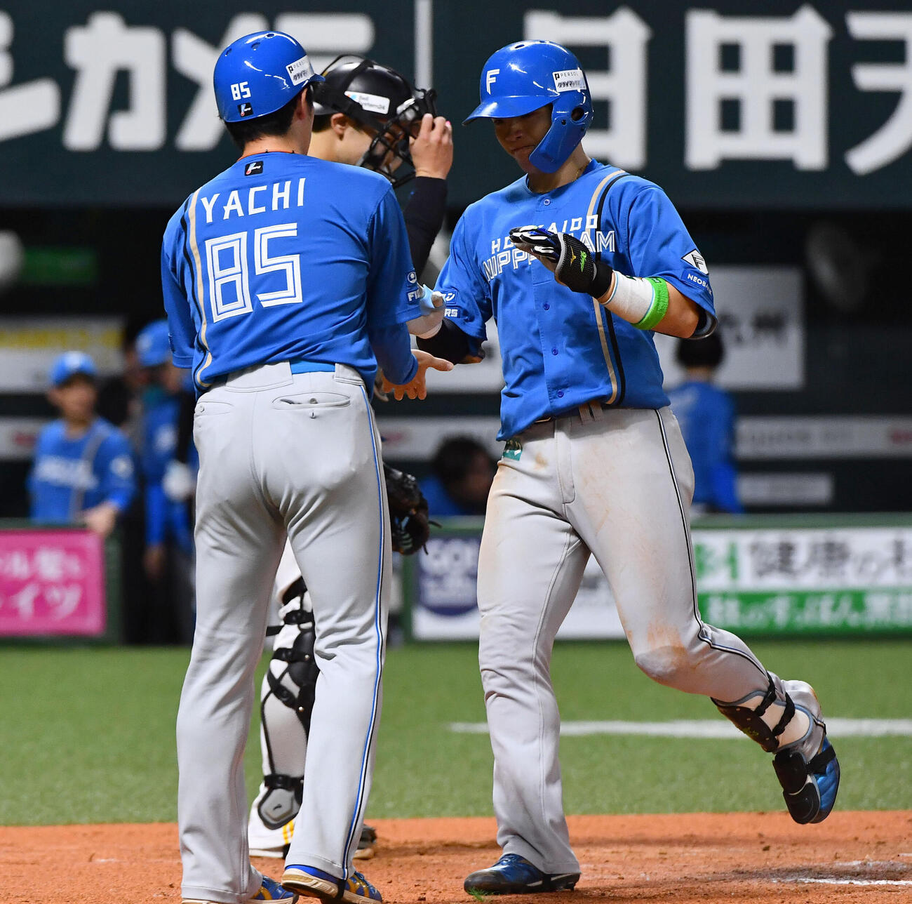 ソフトバンク対日本ハム　7回表日本ハム1死、左越え本塁打を放った郡司裕也（右）は谷内亮太内野守備走塁コーチとタッチを交わす（撮影・岩下翔太）
