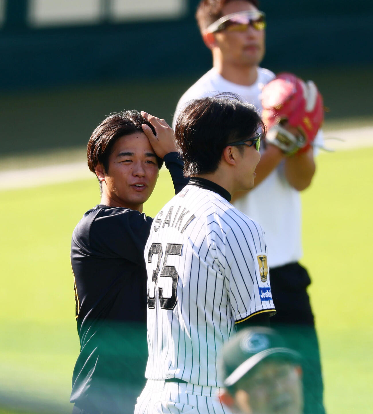 阪神対DeNA　練習中笑顔を見せる阪神高橋遥人。右は才木浩人（撮影・加藤哉）