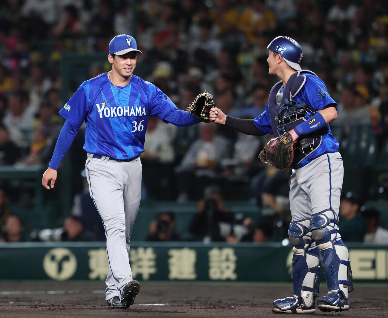 阪神対DeNA 2回裏、走者三塁のピンチをしのぎタッチを交わす松尾汐恩（右）と尾形崇斗（撮影・増田悦実）