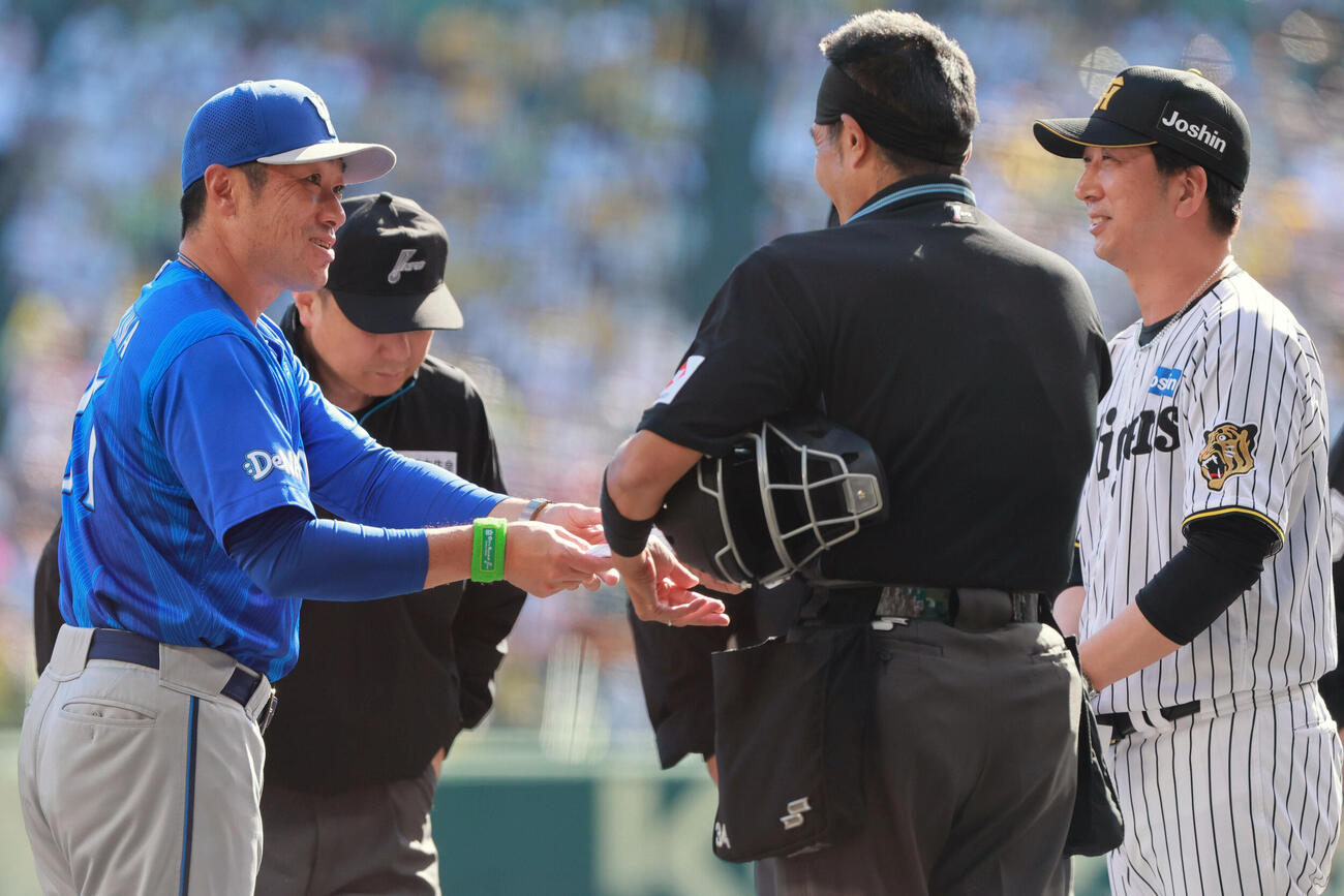 阪神対DeNA　メンバー表の最終確認で言葉をかわす阪神藤川球児監督（右）とDeNA相川亮二監督（撮影・上山淳一）