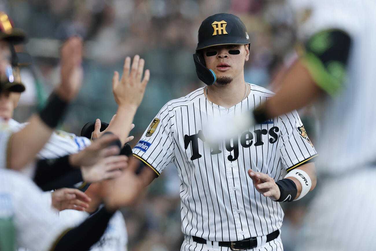 阪神対DeNA 7回裏阪神無死一、三塁、伏見寅威の犠飛で生還しナインに迎えられる佐藤輝明（撮影・前田充）
