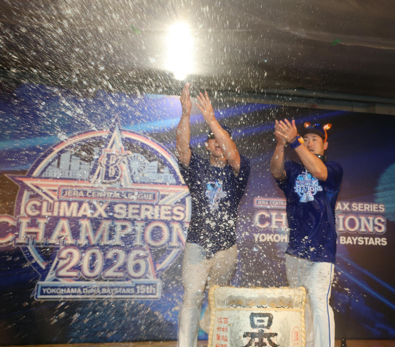 祝勝会でたる酒をまく松尾汐恩（左）と戸柱恭孝（撮影・増田悦実）