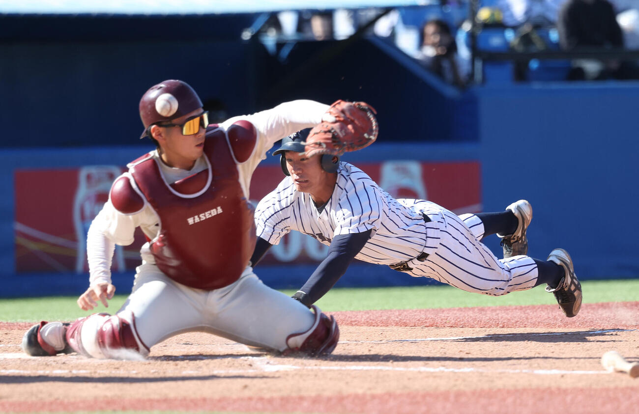 立大対早大　8回表立大無死満塁、村本勇海の打球を二塁手が本塁に悪送球し三塁走者堀田壮真が生還する。早大・尾形樹人捕手（撮影・柴田隆二）