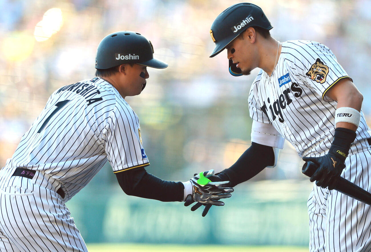 佐藤輝明（右）とタッチをかわす森下翔太（2026年撮影）