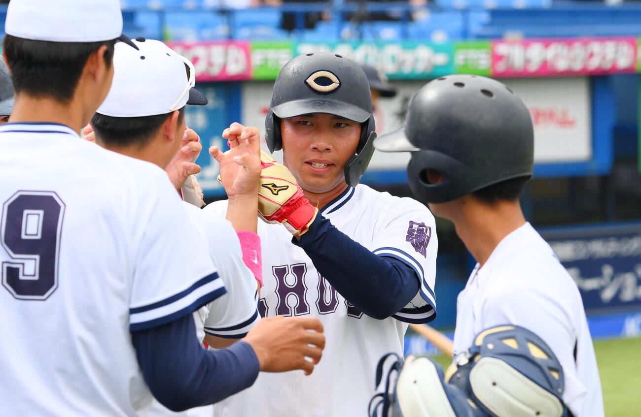 亜大対中大　2回裏中大2死一、三塁、橋本航河の先制適時打で生還した伊藤櫂人（中央）はチームメートとタッチをかわす（撮影・滝沢徹郎）