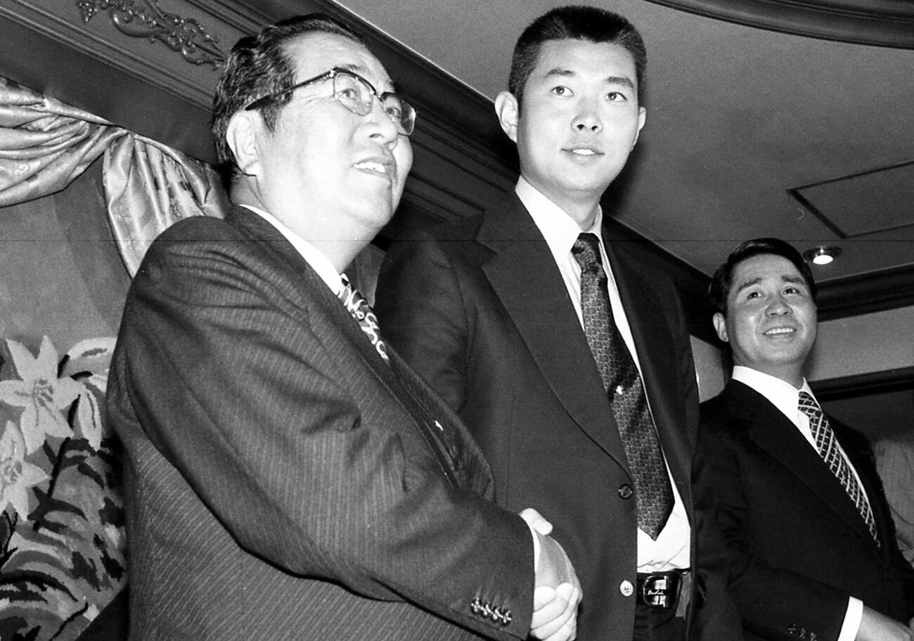 1978年、ドラフト前日の空白の１日を利用して江川卓（中央）との契約発表する巨人の正力亨オーナー（左）