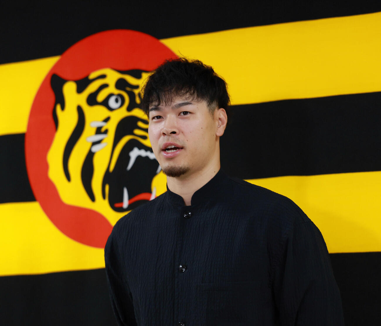 代表質問に応じる佐藤輝明（撮影・上山淳一）