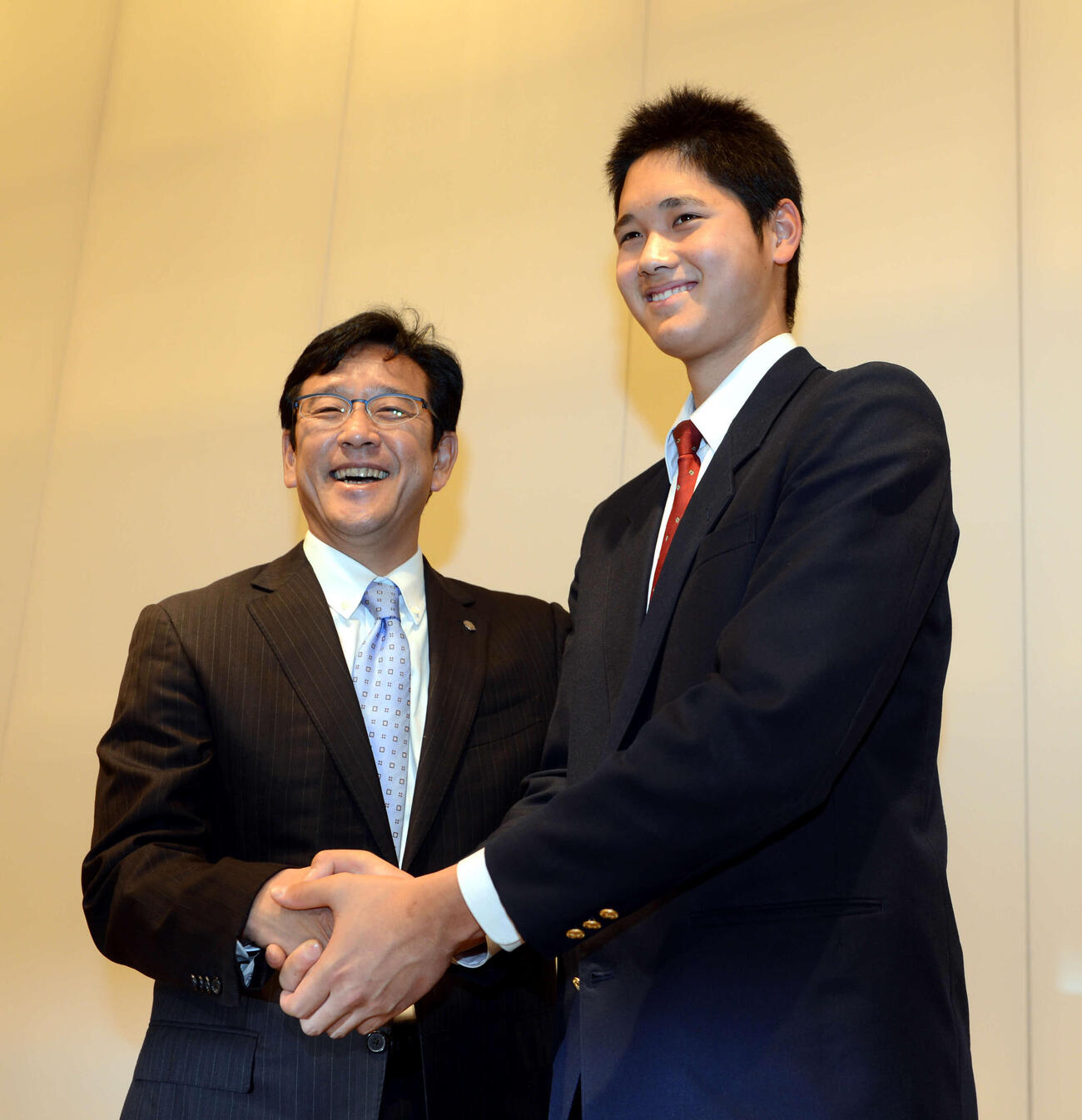 記者会見で、日本ハム入りを正式に表明した大谷（右）は栗山監督と笑顔で握手をかわした（2012年12月9日撮影）