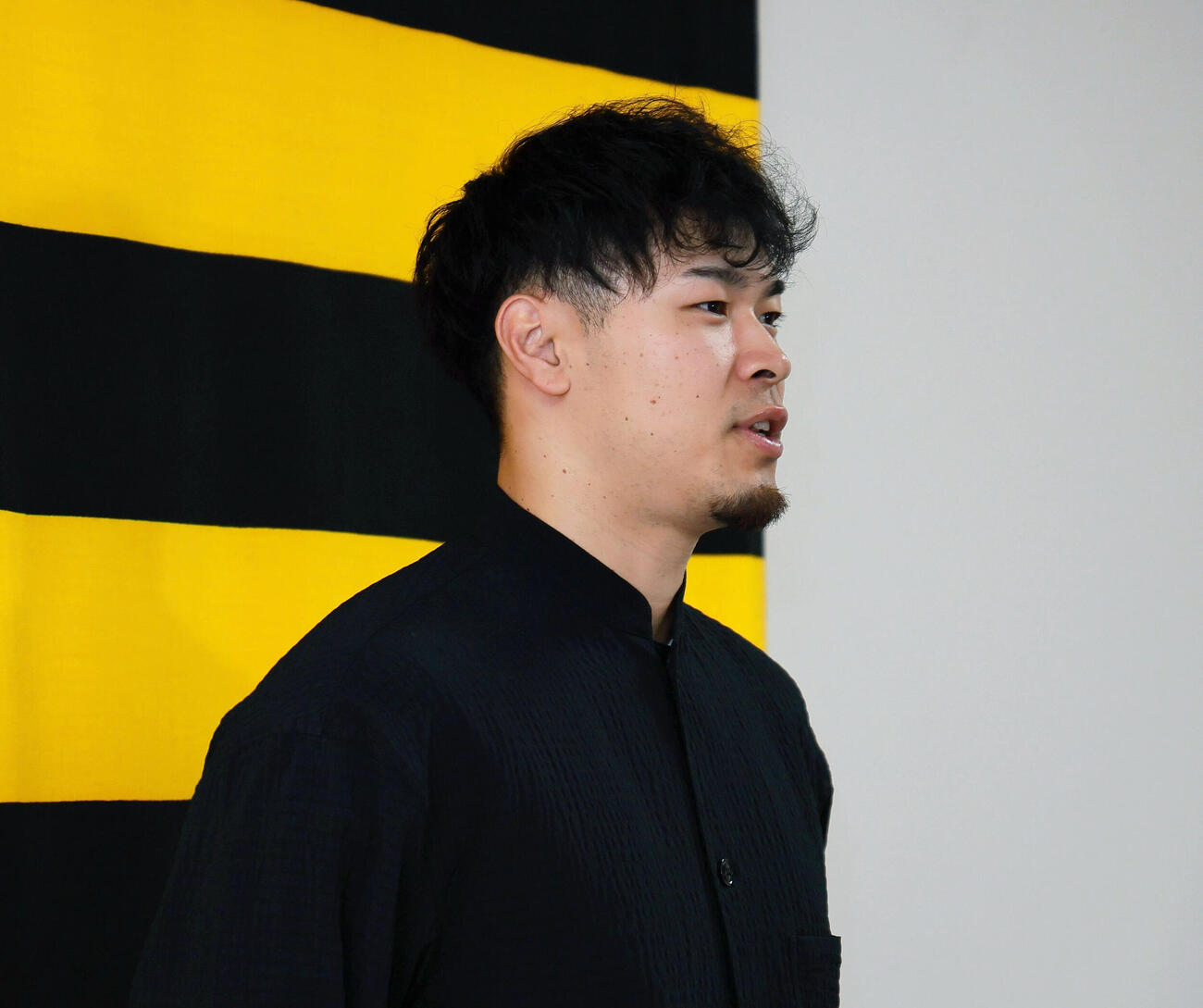 代表質問に応じる佐藤輝明（撮影・上山淳一）