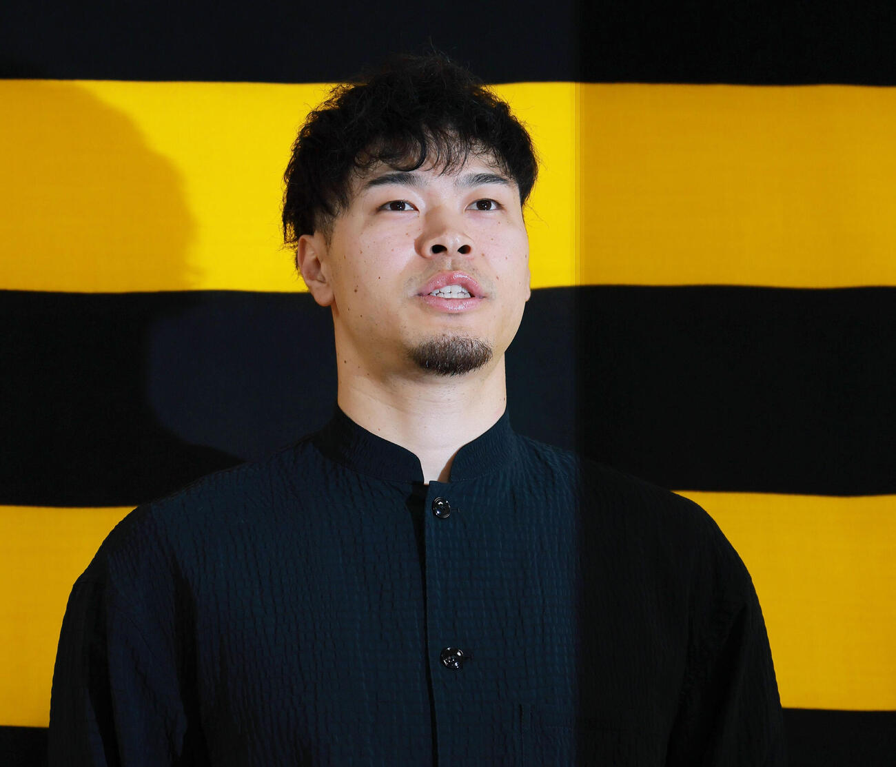 代表質問に応じる佐藤輝明（撮影・上山淳一）