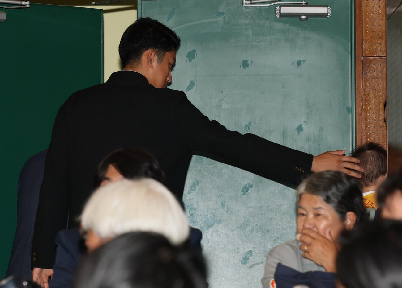 巨人からドラフト1位指名を受けた横浜・織田翔希は会見場を出るときに子供の頭をなでる（撮影・水谷安孝）