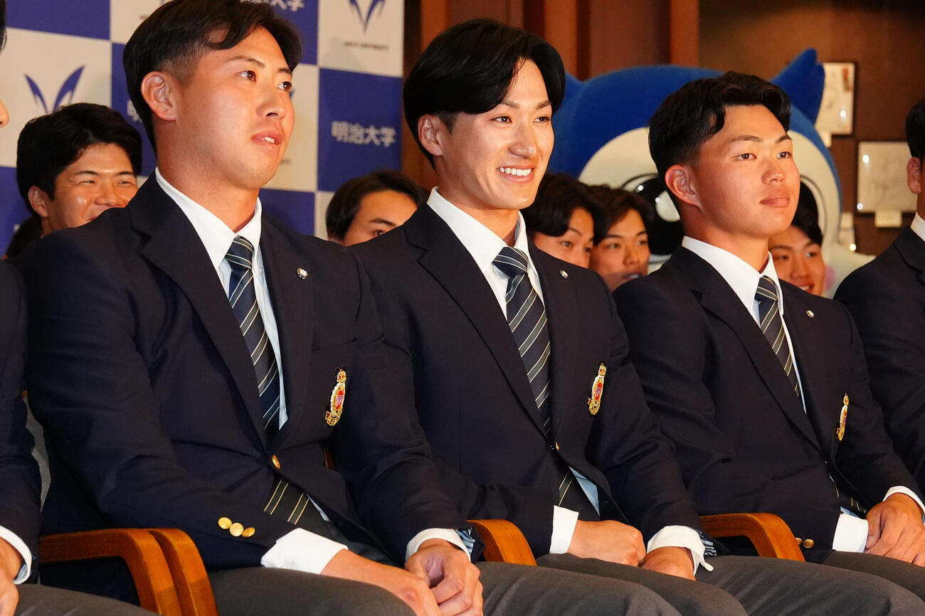 プロ野球ドラフト会議で楽天から2位指名を受けた明大・岡田啓吾（中央）。右は阪神ドラフト1位の榊原七斗（撮影・江口和貴）