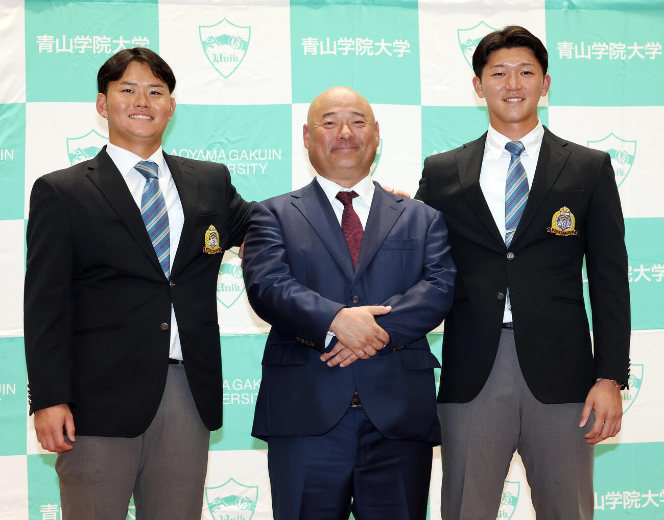青学大・安藤寧則監督（中央）の肩に手を添え笑顔の楽天ドラフト1位の渡部海（左）とソフトバンクドラフト1位の鈴木泰成（撮影・宮地輝）