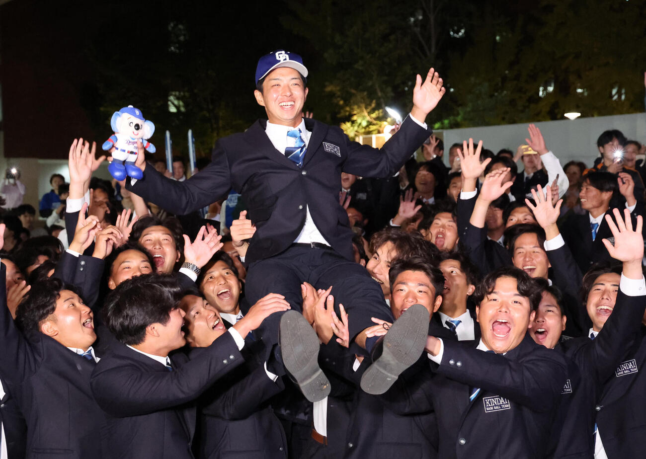 中日から1位で指名された近大・宮原廉はチームメイトから胴上げされる（撮影・西尾就之）